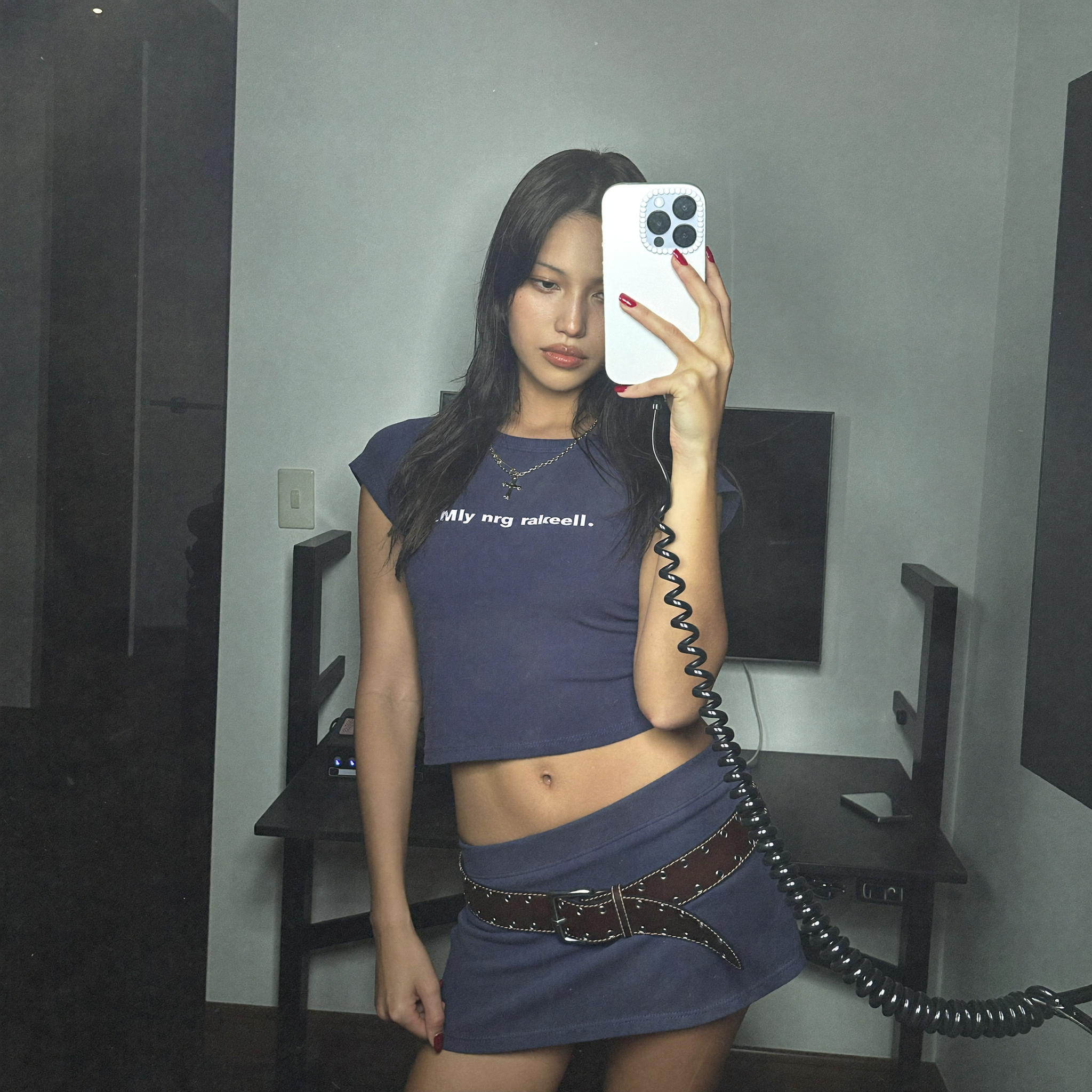 Mara Johanssen standing in a small white-walled apartment holding a yellow tape measure